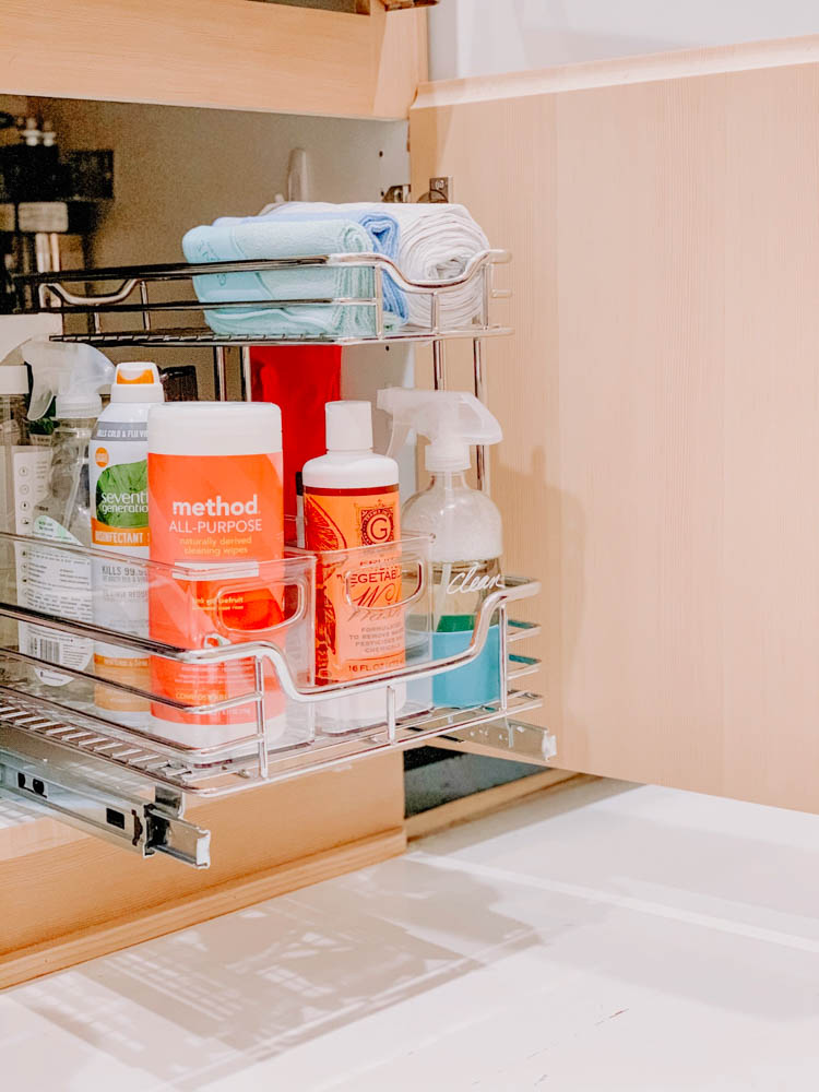 Pull out drawer underneath kitchen sink with healthy cleaning products.